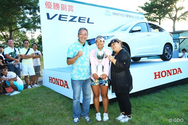 優勝副賞の車を前に記念撮影する鈴木愛、父・健司さん（左）、母・美江さん（右）