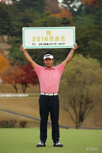 初の賞金王を決め、記念ボードを高々と掲げる池田勇太