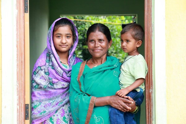 ハビタット・フォー・ヒューマニティ ハビタット・フォー・ヒューマニティらの支援によって建てられたオスマナバード（インド）の家の前に立つマンナビ（45歳）と義理の娘サナと孫のワジード。家は家族に安定とより良い未来への機会を与える。（Habitat for Humanity IndiaRitwik Sawant）