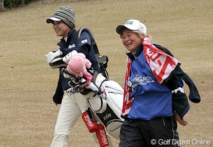 2006年 日韓女子プロゴルフ対抗戦 最終日 横峯さくら ティショットを打ち終え、セカンド地点に向かう横峯とキャディのAKINOさん。って、どっちがキャディやねん！（AKINOさんが上着を脱ぐ間、持つのを代わってあげたのでした）