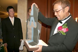 2006年 プレーヤーズラウンジ 片山晋呉 JGTO表彰式で片山晋呉からベストサポート賞を受け取った新岡隆三郎さん（左端）