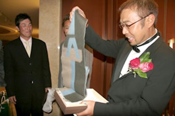 JGTO表彰式で片山晋呉からベストサポート賞を受け取った新岡隆三郎さん（左端）