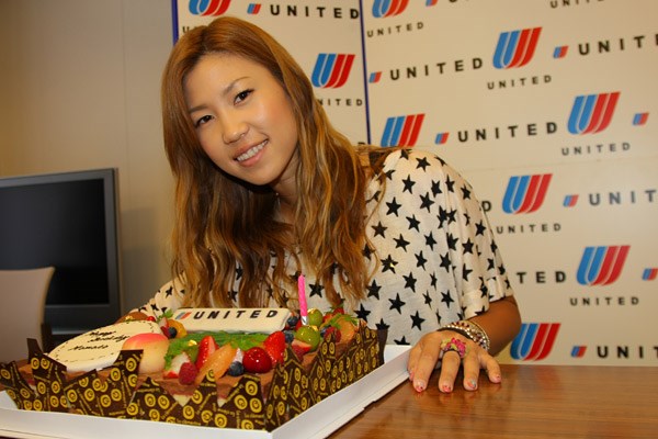 ユナイテッド空港からケーキを受け取りにっこり笑顔の上田桃子