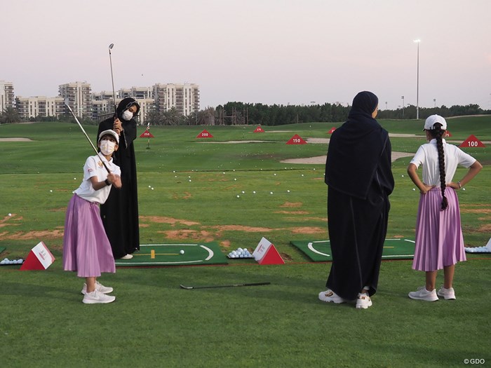 母親らしき人を指導するUAEのジュニアゴルファー 2021年 アジアパシフィック女子アマチュア選手権 3日目 UAEのジュニアゴルファー