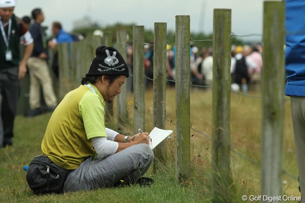 2010年 全英オープン初日 今岡記者 仕事マン今岡。柵の間から選手を覗いて、なにやらメモ。熱心に仕事中です