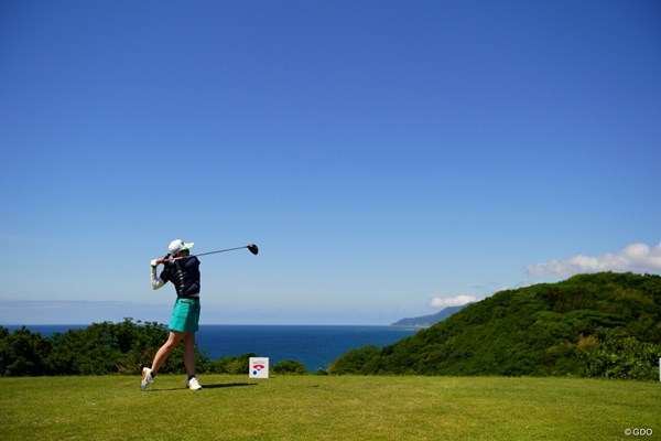 日本海バックにドライバーショット