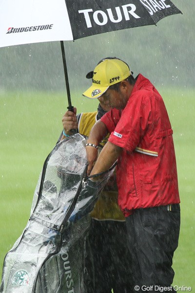 「雨にぬれないようにっと」。レインカバーの隙間から使用クラブを抜き取る池田勇太