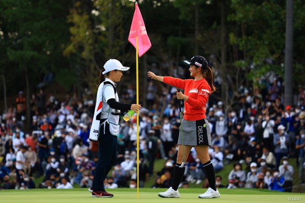 勝利を決めてキャディを務めた高校ゴルフ部の同級生、森田彩聖さん(左)とハグ