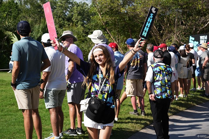 プラカードを掲げるマーシャルの女性。「SHHHH」の文字が 2024年 LIVゴルフ・マヤコバ プラカードを掲げる女性