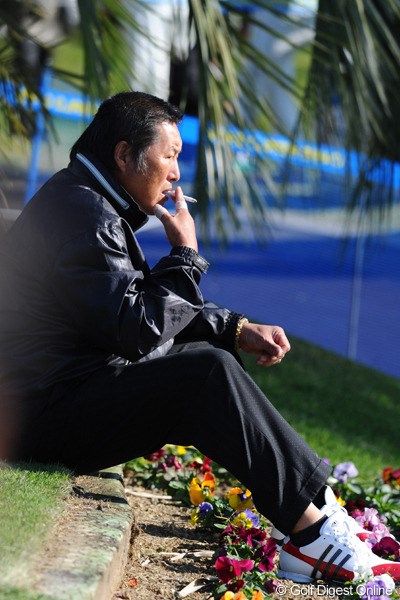 2010年 カシオワールドオープンゴルフトーナメント 2日目 尾崎将司 喫煙所脇のお花畑で一服つけるジャンボさんです。なんかほのぼのと、なごみまんなァ。