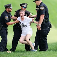 乱入した活動家を取り押さえる警察官ら (Andy Lyons/Getty Images) 2024年 トラベラーズ選手権 4日目