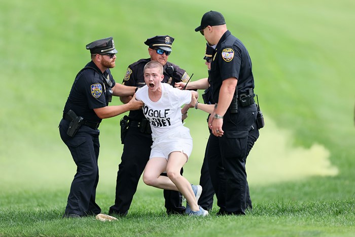 乱入した活動家を取り押さえる警察官ら (Andy Lyons/Getty Images) 2024年 トラベラーズ選手権 4日目