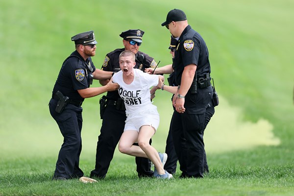 2024年 トラベラーズ選手権 4日目 乱入した活動家を取り押さえる警察官ら (Andy Lyons/Getty Images)