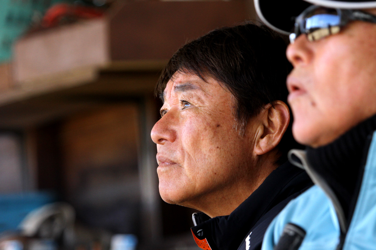 尾崎直道（左）と尾崎健夫が真剣な表情で弾道を追う