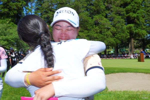 18番グリーンサイドで待ち受けた中村心選手と抱き合って喜ぶ。