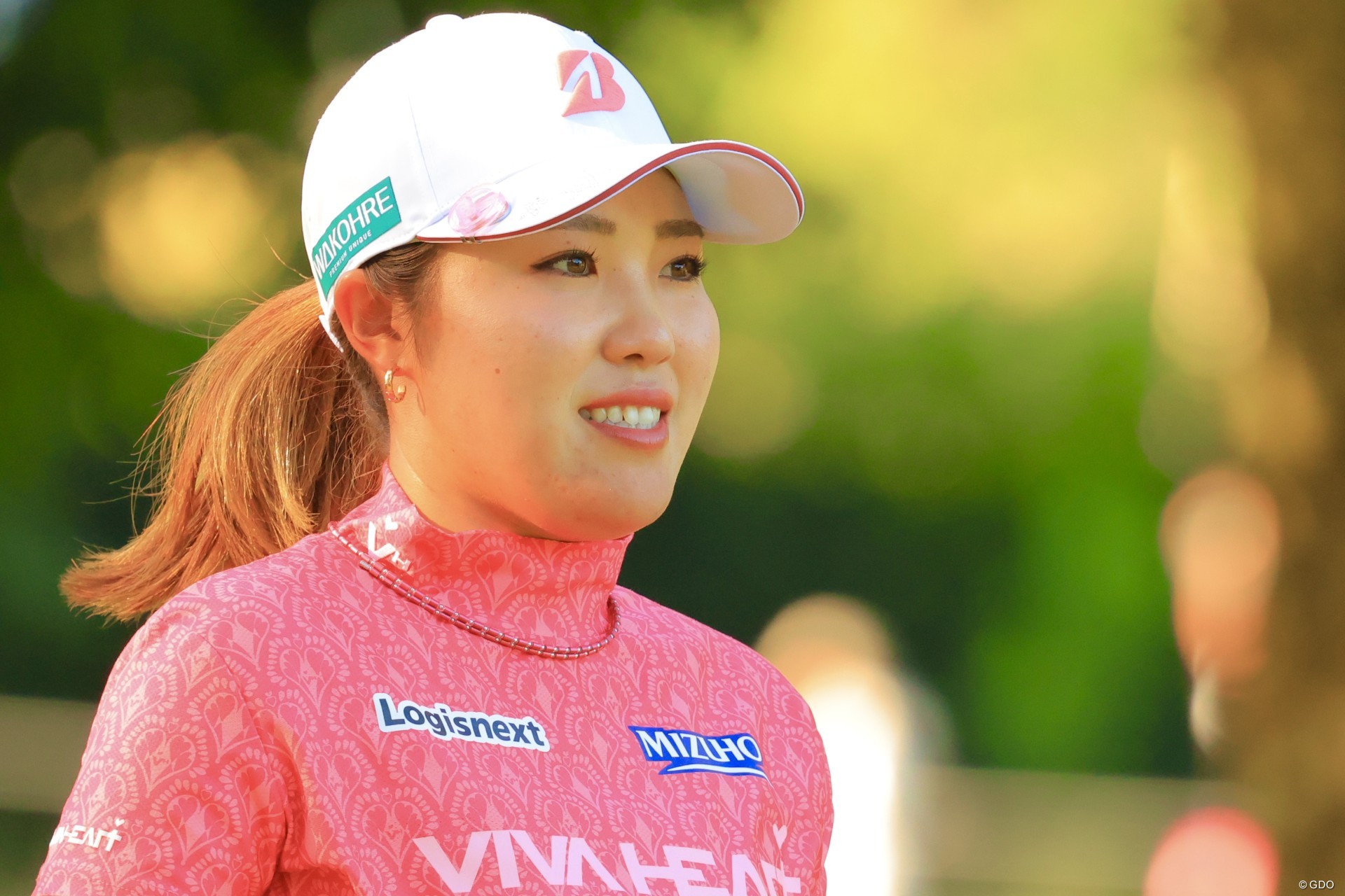 大会カラーのピンクのシャツを着用してプレー