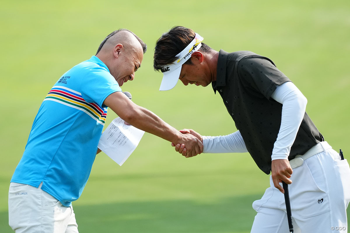 アプローチコンテストでゴルゴ松本とガッチリ握手をする