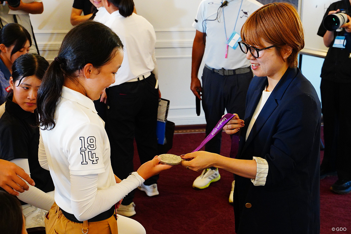 ロンドン五輪で手にした銀メダルを参加者に手に取らせる藤井瑞希さん