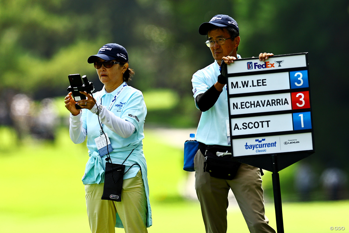 各ホールのスコアを記録するボランティアスタッフ。手には小さなデバイスが