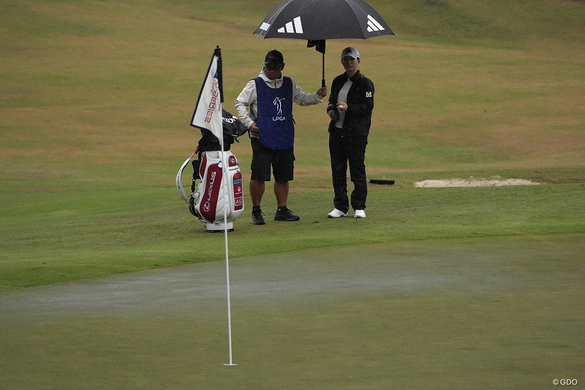 水の浮いたグリーンを見つめる渋野日向子