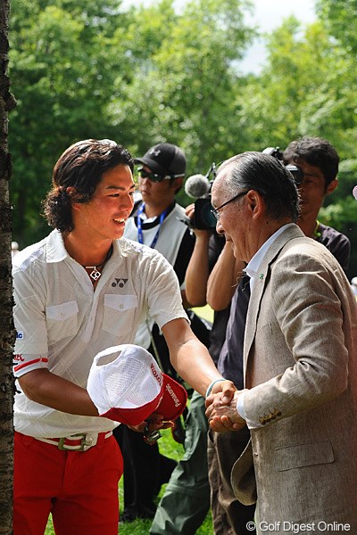 14番のグリーンサイドで観戦する長嶋茂雄大会名誉会長と握手を交わす石川遼