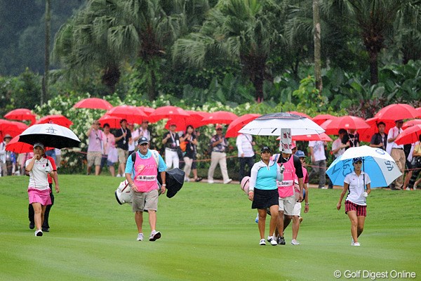 2012年 サイム・ダービー LPGA マレーシア 3日目 上田桃子＆宮里美香  雨季ということで、突然のスコールに備えて、ギャラリー全員（！）に傘がプレゼントされていました。ずぶ濡れになっているのはキャディとカメラマンだけでした（泣）。