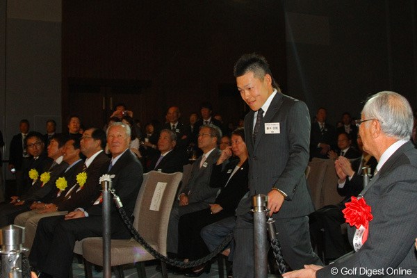 新人賞の藤本佳則は、安西JGA会長（手前）や永久シード5人の前を会釈しながら登壇