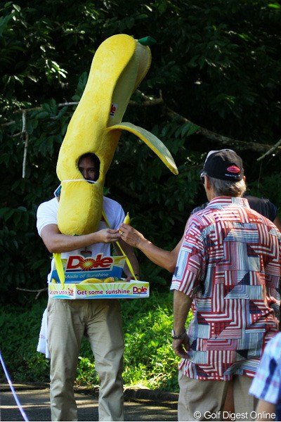 ギャラリーにバナナを配る男。暑そう。
