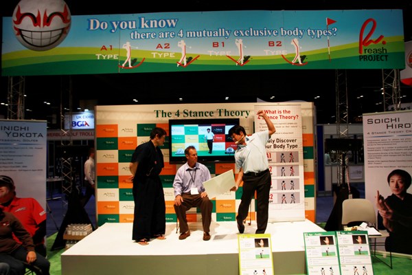 2013年PGAマーチャンダイズショー フォトギャラリーレポート 横田真一＝4スタンス理論を広めるブースを出し、自ら壇上に上がって熱心に説明する横田プロ。体験するアメリカ人も感心しきり