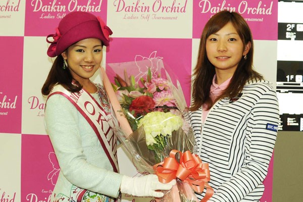 ミス沖縄スカイブルーの又吉芽生さん（写真左）に花束を贈られ、笑顔で応える斉藤愛璃