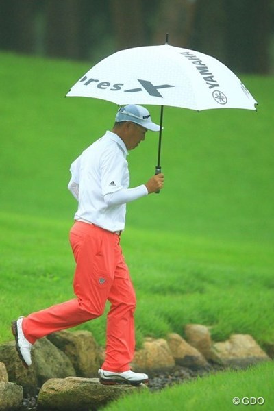 2013年 日本ゴルフツアー選手権 Shishido Hills 初日 谷口徹 一日を通して霧雨が続いた初日。谷口徹はレインパンツで傘をさし雨対策はバッチリOK