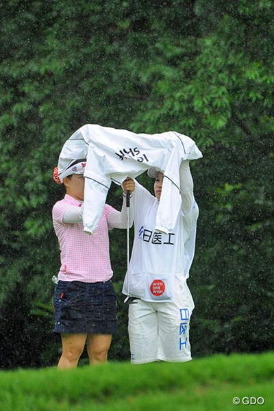 2013年 日医工女子オープンゴルフトーナメント 最終日 井芹美保子 なんせ突然に降り出すもんやから傘も間に合いませんねん・・・。急場をしのぎのカッパを広げて雨宿り・・・。この直後に2度目の中断となります。