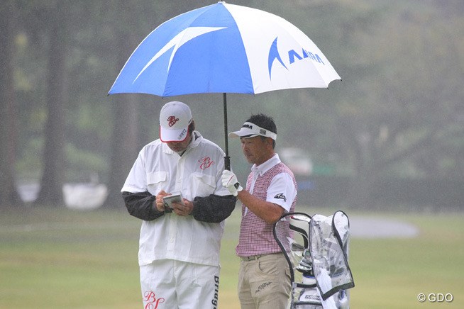 キャディの中居謹蔵氏に傘を差し出すプロ 13年 ブリヂストンオープンゴルフトーナメント 2日目 久保谷健一 フォトギャラリー Gdo